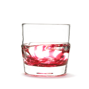 Hand blown glass whiskey glass, clear with a swirl of cranberry glass on the bottom.
