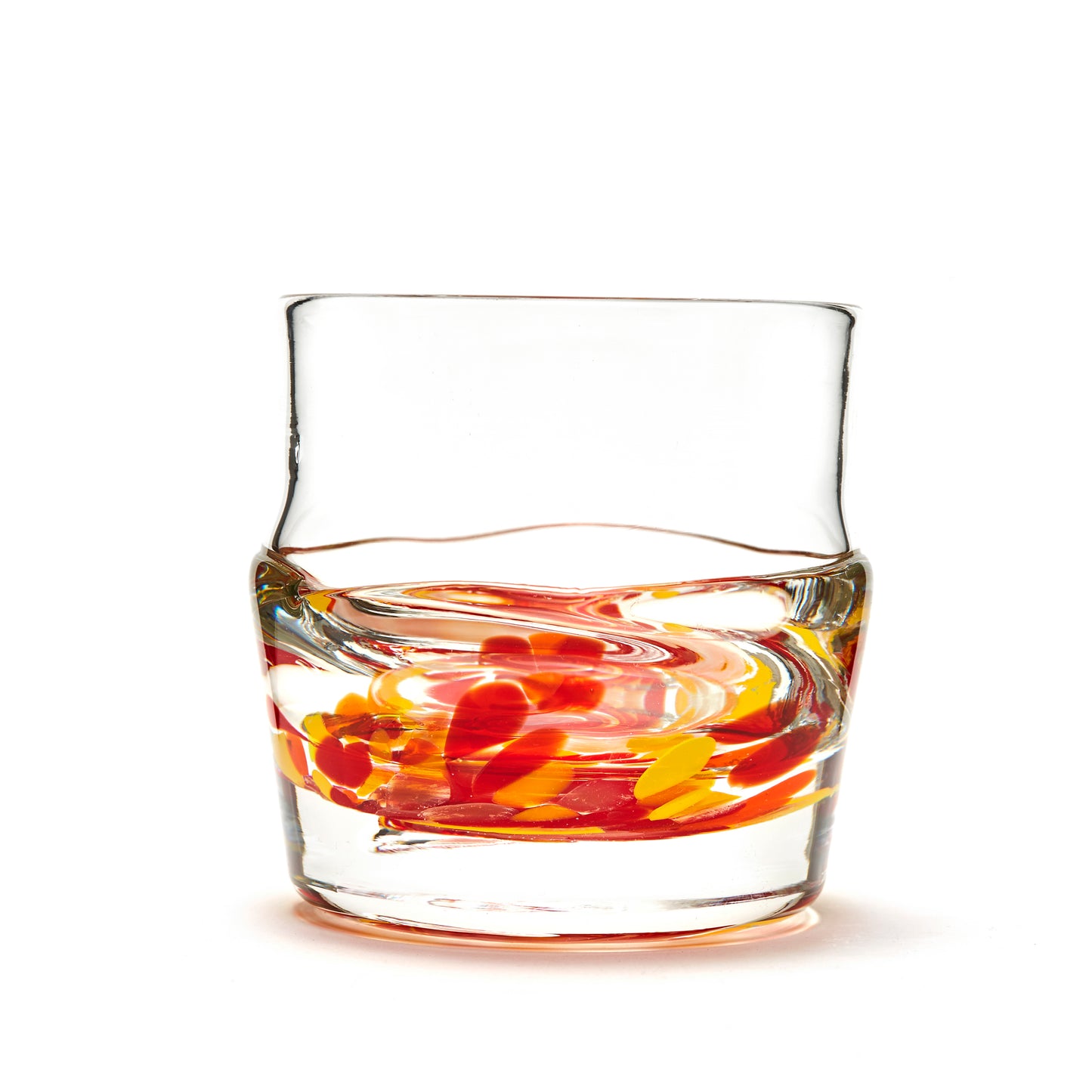Load image into Gallery viewer, Hand blown glass whiskey glass, clear with a swirl of red, yellow, and orange glass on the bottom. Colour combination is called &amp;quot;Sunburst.&amp;quot;
