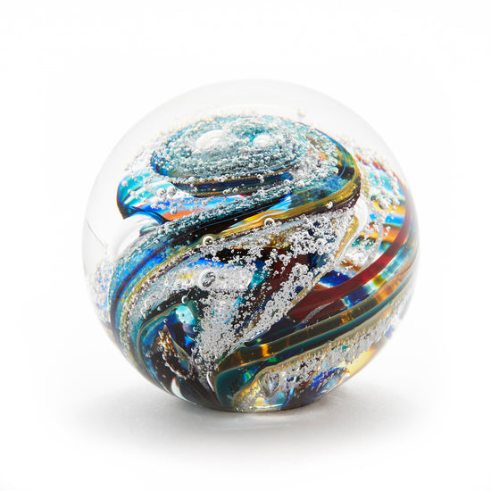 Load image into Gallery viewer, Round memorial glass art paperweight with cremation ash. Purple, blue, yellow, red, orange, green, and white glass. Colour combination is called &amp;quot;Multi.&amp;quot;
