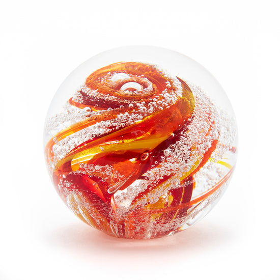 Load image into Gallery viewer, Round memorial glass art paperweight with cremation ash. Red, yellow, and orange glass. Colour combination is called &amp;quot;Sunburst.&amp;quot;
