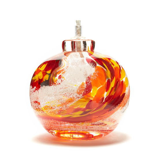 Round memorial glass art eternal flame oil lamp with cremation ash. Red, yellow, and orange glass. Colour combination is called "Sunburst."